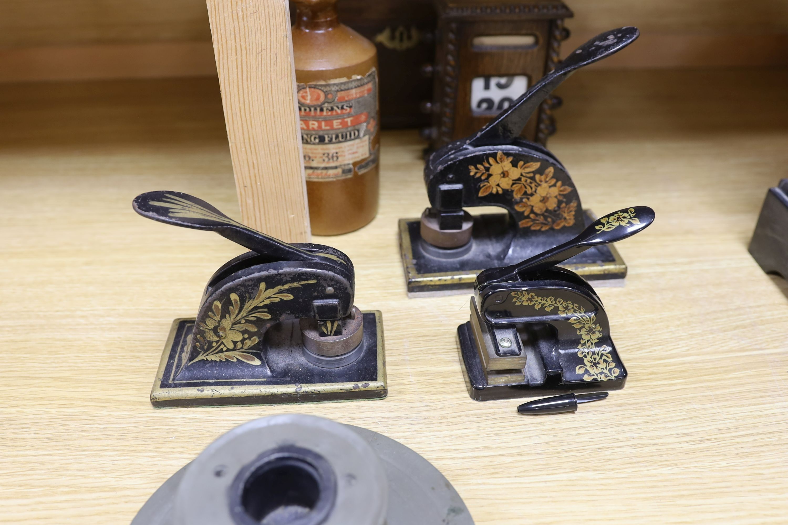 Three Victorian style desk embossing stamps, a terracotta bottle of Stephens 'Scarlet Writing Fluid', a desk calendar, oak box and a desk stand